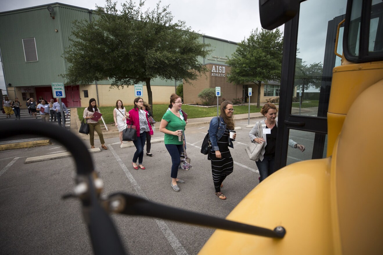 A group of real estate agents boards a school bus for a six-hour tour of Austin ISD schools. 